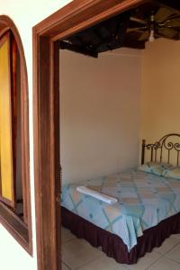 a bedroom with a bed and a mirror at Hotel Villa Florencia Centro Histórico in San Salvador