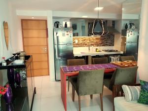a kitchen with a dining table and a kitchen with stainless steel appliances at Israel Flat Tambau 209 PRIME in João Pessoa