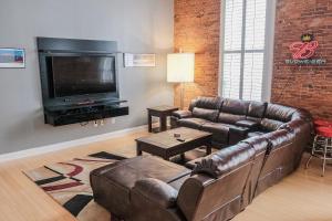 a living room with a leather couch and a flat screen tv at Modern Lofts next to Georgia St. & Convention Ctr. in Indianapolis