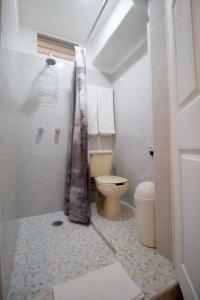 Casa Zac Nicte Mx-Departamento BALAM في كانكون: حمام ابيض مع مرحاض ودش