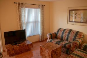 a living room with a couch and a television at Lago Mar Motel and Apartments in Lake Worth