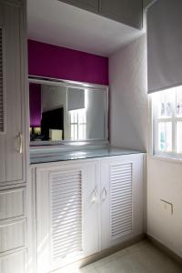 a kitchen with white cabinets and a mirror at Casa Zac Nicte Mx-Habitacion IXCHEL in Cancún