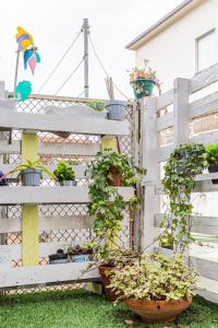 a white fence with potted plants on it at Luizinho House in Vila Nova de Gaia