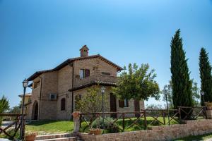 Agriturismo alla Solagna في Colli del Tronto: بيت حجري قديم وامامه سياج