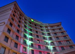 Holiday Inn Dallas Market Center, an IHG Hotel في دالاس: مبنى الفندق عليه لافته في الليل