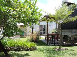 a garden with a table and trees in front of a house at Casa Lihuel in Colón