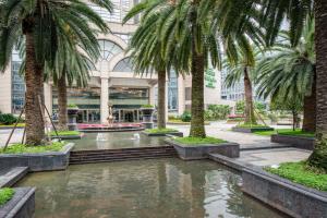 a courtyard with palm trees in front of a building at Holiday Inn Chengdu Xindu, an IHG Hotel in Chengdu