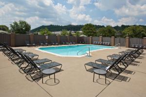 un grupo de sillas sentadas alrededor de una piscina en Holiday Inn Cincinnati-Riverfront, an IHG Hotel, en Covington