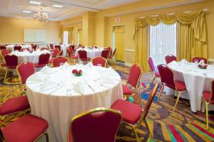 a banquet room with white tables and red chairs at Holiday Inn Chantilly-Dulles Expo Airport by IHG in Chantilly +47 photos