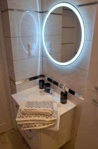 een badkamer met een wastafel en een spiegel bij Apartament DeLuxe 1 in Oświęcim