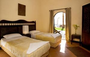 a bedroom with two beds and an open doorway at Dahab Paradise in Dahab