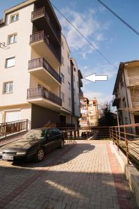 une voiture garée dans un parking à côté d'un bâtiment dans l'établissement Dzusy Apartments, à Ohrid