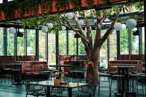 a restaurant with tables and chairs and a tree at Marion Hotel in Adelaide