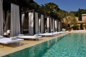a row of chaise lounge chairs next to a swimming pool at MUSE Saint Tropez - Small Luxury Hotels of the World in Saint-Tropez