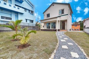 a house with a palm tree next to a walkway at Private Villa Espacio Onna in Inbu