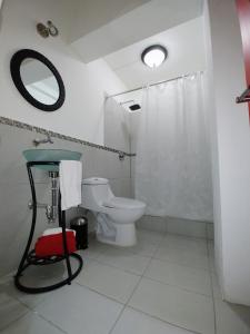 a bathroom with a toilet and a sink and a mirror at Cayalito Apart Hotel in Guatemala