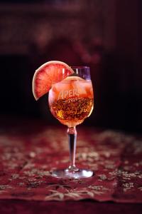 a wine glass with a grapefruit slice on a table at Hotel und Restaurant Peking in Riesa