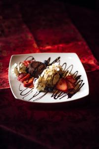 a plate of food with ice cream and strawberries at Hotel und Restaurant Peking in Riesa