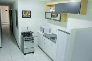 a small kitchen with a stove and a sink at Pousada Residencial Milagre 02 in Juazeiro do Norte