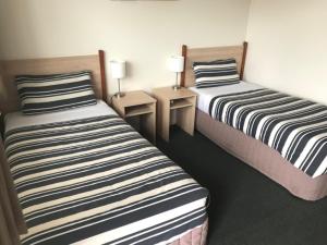 
A bed or beds in a room at Beachcomber Motel & Apartments
