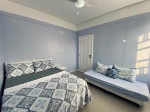 1 dormitorio con cama y banco. en Aparts Ilha Centro-casa 2 qtos e casa 1 qto mezanino, en Florianópolis