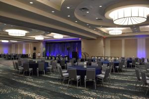 um salão de banquetes com mesas e cadeiras azuis em Holiday Inn Cincinnati North West Chester, an IHG Hotel em West Chester