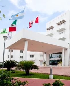a white building with flags on top of it at Ocean View Cancun Arenas in Cancún