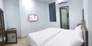 biała sypialnia z łóżkiem i lustrem w obiekcie Like Family Hotel w mieście Nha Trang
