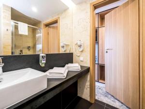 a bathroom with a sink and a mirror at Mercure Jelenia Góra in Jelenia Góra