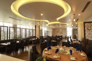 comedor con mesas y sillas y un gran techo en Central Hotel Thanh Hoa en Thanh Hóa
