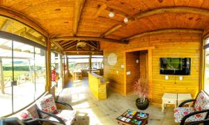 a living room with a tv on a wooden wall at Pousada Morada da Serra in Cambará