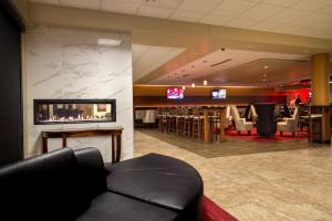 a hotel lobby with a fireplace and a bar at Holiday Inn Des Moines-Airport Conf Center, an IHG Hotel in Des Moines