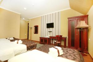 a hotel room with two beds and a desk at Khujand Deluxe Hotel in Khujand