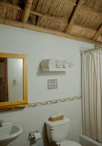 La salle de bains est pourvue de toilettes, d'un lavabo et d'un miroir. dans l'établissement Muyuyo Lodge, à Ayangue