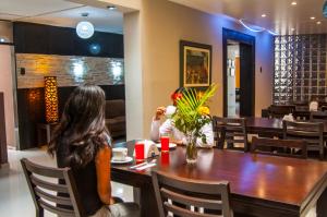 a woman sitting at a table in a restaurant at Hotel Chimu in Trujillo