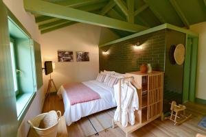 um quarto com uma cama e uma parede de tijolos em Vila Coura em Amarante