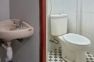 a bathroom with a toilet and a sink at RedDoorz @ Hotel Yaki Mamuju in Rimuku