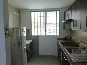 a kitchen with a white refrigerator and a window at Dpto Moderno Frente al Mar. Edf: Deymar 7mo Piso in Tonsupa