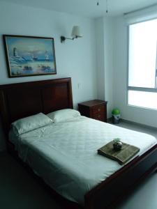 a bedroom with a large bed with a tray on it at Dpto Moderno Frente al Mar. Edf: Deymar 7mo Piso in Tonsupa