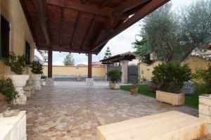 an outdoor patio with a wooden roof and a table at EneaHouse in Fiumicino