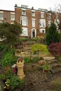 a garden in front of a large brick building at Captains Cabin in Whitby