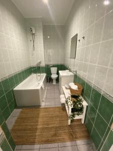 ein Badezimmer mit einer Badewanne, einem WC und einem Waschbecken in der Unterkunft Zarya Lux Hotel in Prokop'yevsk