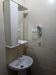 a bathroom with a sink and a mirror at Tropicana Inn in Uralsk