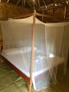 a bed with a canopy in a room at Back Trippers Inn in San Vicente