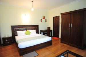a bedroom with a large bed and a wooden cabinet at Ireby Tea Estate Bungalow in Hatton