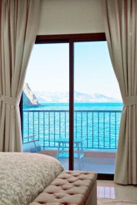 a bedroom with a view of the ocean from a balcony at Apartment 004 - Mina Al Fajer in Fujairah