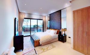 a bedroom with a bed and a large window at Apartment 004 - Mina Al Fajer in Fujairah