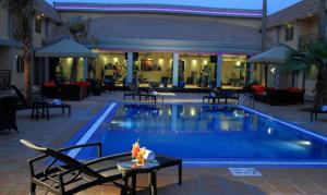 a pool with chairs and tables next to a hotel at Holiday Inn Al Khobar - Corniche by IHG in Al Khobar