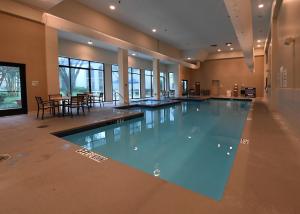 una grande piscina in una sala con tavoli e sedie di Holiday Inn Irving Las Colinas, an IHG Hotel a Irving