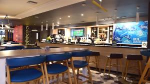 a restaurant with tables and chairs in it at Holiday Inn Glasgow - East Kilbride, an IHG Hotel in East Kilbride